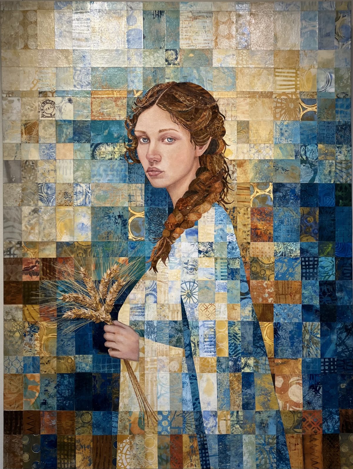 Portrait of a young woman with auburn braided hair, holding a bundle of wheat in her hand, dressed in shades of blue and gold, against a mosaic-like background with squares of intricate textures and patterns.