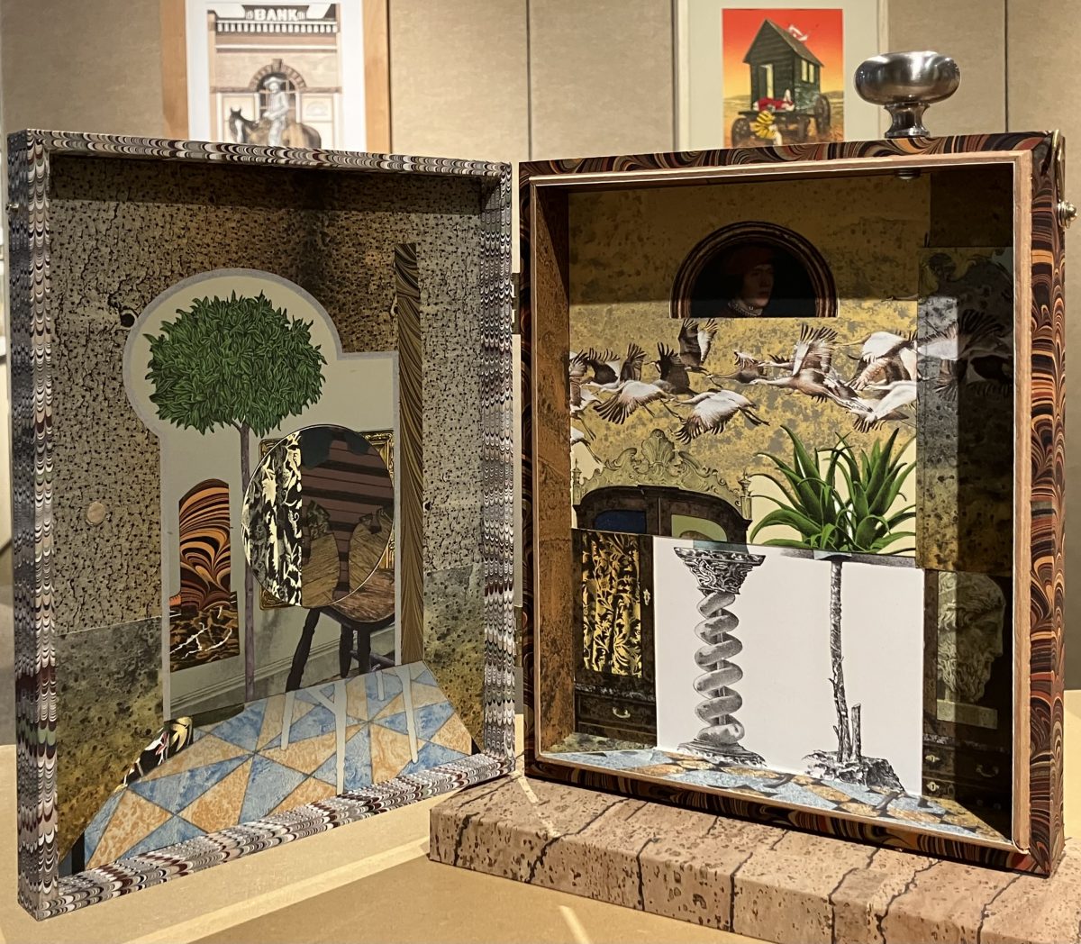 A mixed-media sculpture depicting a figure with a red cap standing on a pedestal. The figure’s body is painted with abstract patterns, and in the background, additional sculptural works are displayed.