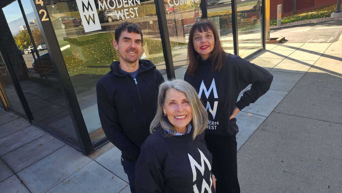 three Modern West staff members standing outside the gallery’s new location at 242 South Temple, with large glass windows behind them
